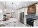 The kitchen features an oven and stove top with a wooden hood and stainless refrigerator at 610 Casabella Dr, Bradenton, FL 34209