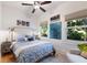 Well-lit bedroom featuring large windows, ceiling fan, decorative art, and natural light at 610 Casabella Dr, Bradenton, FL 34209