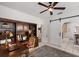 Bright office with a dark wood bookcase, desk, and sliding door to kitchen with barn door access at 610 Casabella Dr, Bradenton, FL 34209