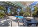 Relaxing screened pool area features a dining table, lounge chairs, and lush tropical landscaping at 610 Casabella Dr, Bradenton, FL 34209