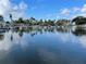 Calm canal view with palm trees reflecting on the water's surface under a blue sky at 610 Casabella Dr, Bradenton, FL 34209