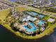 Aerial view showcases community pool, tennis courts, playground, and clubhouse amenities by the lake at 6326 Brevada Ln, Apollo Beach, FL 33572