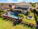 Aerial view showcasing a home with a large swimming pool, outdoor kitchen, patio, and lush landscaping at 6326 Brevada Ln, Apollo Beach, FL 33572