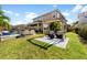 Beautiful backyard features a pergola with seating, lush lawn, and a glimpse of the pool at 6326 Brevada Ln, Apollo Beach, FL 33572