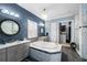 The bathroom features a soaking tub, and vanities, a chandelier, and a walk-in closet with custom organization at 6326 Brevada Ln, Apollo Beach, FL 33572