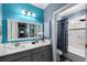 Bright bathroom with a modern vanity, a large mirror, and a shower-tub combination with a blue floral shower curtain at 6326 Brevada Ln, Apollo Beach, FL 33572