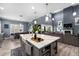 Open-concept kitchen island featuring a sink, bar stools, and views into the spacious living area at 6326 Brevada Ln, Apollo Beach, FL 33572