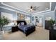 This is a large main bedroom with blue walls, tray ceiling, wood furniture, and an en suite bathroom with a soaking tub at 6326 Brevada Ln, Apollo Beach, FL 33572