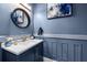 The powder room has a blue wall, a granite vanity, a brushed-gold faucet, and a round mirror at 6326 Brevada Ln, Apollo Beach, FL 33572