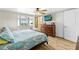 Bedroom features wood flooring, ceiling fan, and a large glass enclosed porch at 6518 Leeside Isle, Hudson, FL 34667