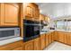 Kitchen with updated black appliances, wooden cabinetry, and tile backsplash for style and functionality at 6518 Leeside Isle, Hudson, FL 34667