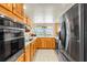 Bright kitchen with stainless steel appliances, wood cabinets, and window overlooking the backyard at 6518 Leeside Isle, Hudson, FL 34667