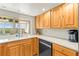 Modern kitchen with stainless steel appliances, wood cabinetry, and scenic view from the sink area at 6518 Leeside Isle, Hudson, FL 34667