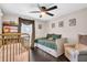 Cozy bedroom featuring dark wood floors, a daybed, and a gold crib at 7115 Edenwood Pl, Tampa, FL 33615