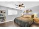 Cozy bedroom with a ceiling fan, natural light, a comfortable queen bed, and decorative wall shelves at 7115 Edenwood Pl, Tampa, FL 33615