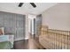 Bedroom with dark wood floors and a gold crib in front of gray closet doors at 7115 Edenwood Pl, Tampa, FL 33615