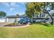 Charming home with a manicured lawn, unique landscaping, and a screened-in pool area at 7115 Edenwood Pl, Tampa, FL 33615