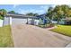 Exterior shot of the house with a lush front yard and driveway at 7115 Edenwood Pl, Tampa, FL 33615