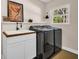 Well-equipped laundry room with black washer/dryer, utility sink, and butcher block countertop at 7115 Edenwood Pl, Tampa, FL 33615