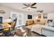 Bright living room featuring ceiling fans, hardwood floors, stylish décor, and an adjacent home office setup at 7115 Edenwood Pl, Tampa, FL 33615