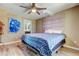 Cozy bedroom features a comfortable bed with stylish blue patterned linens, a ceiling fan and artwork at 7432 Sunshine Skyway S Ln # 206, St Petersburg, FL 33711