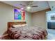 This bedroom features a comfortable bed, ceiling fan, and colorful art, creating a relaxing atmosphere at 7432 Sunshine Skyway S Ln # 206, St Petersburg, FL 33711