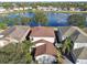 Aerial view of a house with a well-maintained roof, surrounded by trees and near a peaceful pond at 7945 Carriage Pointe Dr, Gibsonton, FL 33534