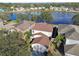 Aerial view of a house with a well-maintained roof, surrounded by trees and near a peaceful pond at 7945 Carriage Pointe Dr, Gibsonton, FL 33534