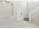 View of the entryway, featuring a tiled floor, white front door, staircase, and decorative shelving at 7945 Carriage Pointe Dr, Gibsonton, FL 33534