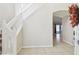 Bright foyer showcasing ceramic tile flooring, a staircase, and an arched entry to the living area at 7945 Carriage Pointe Dr, Gibsonton, FL 33534