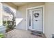 View of the front porch featuring neutral brick flooring, and a decorative wreath on the front door at 7945 Carriage Pointe Dr, Gibsonton, FL 33534