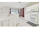 Modern kitchen with white cabinets, white appliances, and a bright window at 7945 Carriage Pointe Dr, Gibsonton, FL 33534