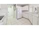 Bright kitchen with white appliances, white cabinets, and tile floor at 7945 Carriage Pointe Dr, Gibsonton, FL 33534