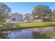 Pond view with manicured lawns, white picket fences, and mature trees enhance backyard appeal at 7945 Carriage Pointe Dr, Gibsonton, FL 33534