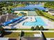 Aerial view of a beautiful community pool, tennis court, playground and pond at 7945 Carriage Pointe Dr, Gibsonton, FL 33534