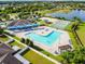 Aerial view of a beautiful community pool, tennis court, playground and pond at 7945 Carriage Pointe Dr, Gibsonton, FL 33534