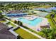 Aerial view of a beautiful community pool, tennis court, playground and pond at 7945 Carriage Pointe Dr, Gibsonton, FL 33534