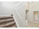 Carpeted staircase with white banister and neutral walls at 7945 Carriage Pointe Dr, Gibsonton, FL 33534