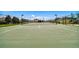 The community tennis court features a green surface, white lines, a net, and lights at 7945 Carriage Pointe Dr, Gibsonton, FL 33534