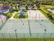 Community tennis court featuring a green surface, white lines, a net, and lights at 7945 Carriage Pointe Dr, Gibsonton, FL 33534