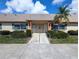 Building exterior with beige walls, dark-green shutters, and well-maintained landscaping at 8445 Jeffrey N # 8445, Pinellas Park, FL 33781