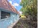 Home exterior with blue siding, brown roof, brick walkway and lush trees at 8445 Jeffrey N # 8445, Pinellas Park, FL 33781