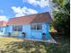 Home exterior featuring a blue facade, a brown roof, a yellow bench, and lush landscaping at 8445 Jeffrey N # 8445, Pinellas Park, FL 33781