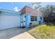 Inviting blue home with a white garage door, a white front door, and a cozy yellow bench at 8445 Jeffrey N # 8445, Pinellas Park, FL 33781