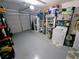 View of garage featuring laundry machines, shelving for storage and epoxy flooring at 8445 Jeffrey N # 8445, Pinellas Park, FL 33781