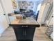 Close up of the kitchen island featuring a butcher block top, storage, and adjacent rooms at 8445 Jeffrey N # 8445, Pinellas Park, FL 33781