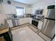 Efficient kitchen features stainless steel appliances, white cabinets, and gray countertops at 8445 Jeffrey N # 8445, Pinellas Park, FL 33781