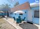 View of patio featuring outdoor seating under an umbrella with a red-tiled roof home at 8445 Jeffrey N # 8445, Pinellas Park, FL 33781