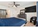 Inviting bedroom with dark furniture, blue accents, a ceiling fan, and laminate floors at 8990 Forge Breeze Loop, Wesley Chapel, FL 33545