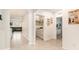 Well-lit hallway featuring storage cabinets, leading to laundry room, and the home's other spaces at 8990 Forge Breeze Loop, Wesley Chapel, FL 33545